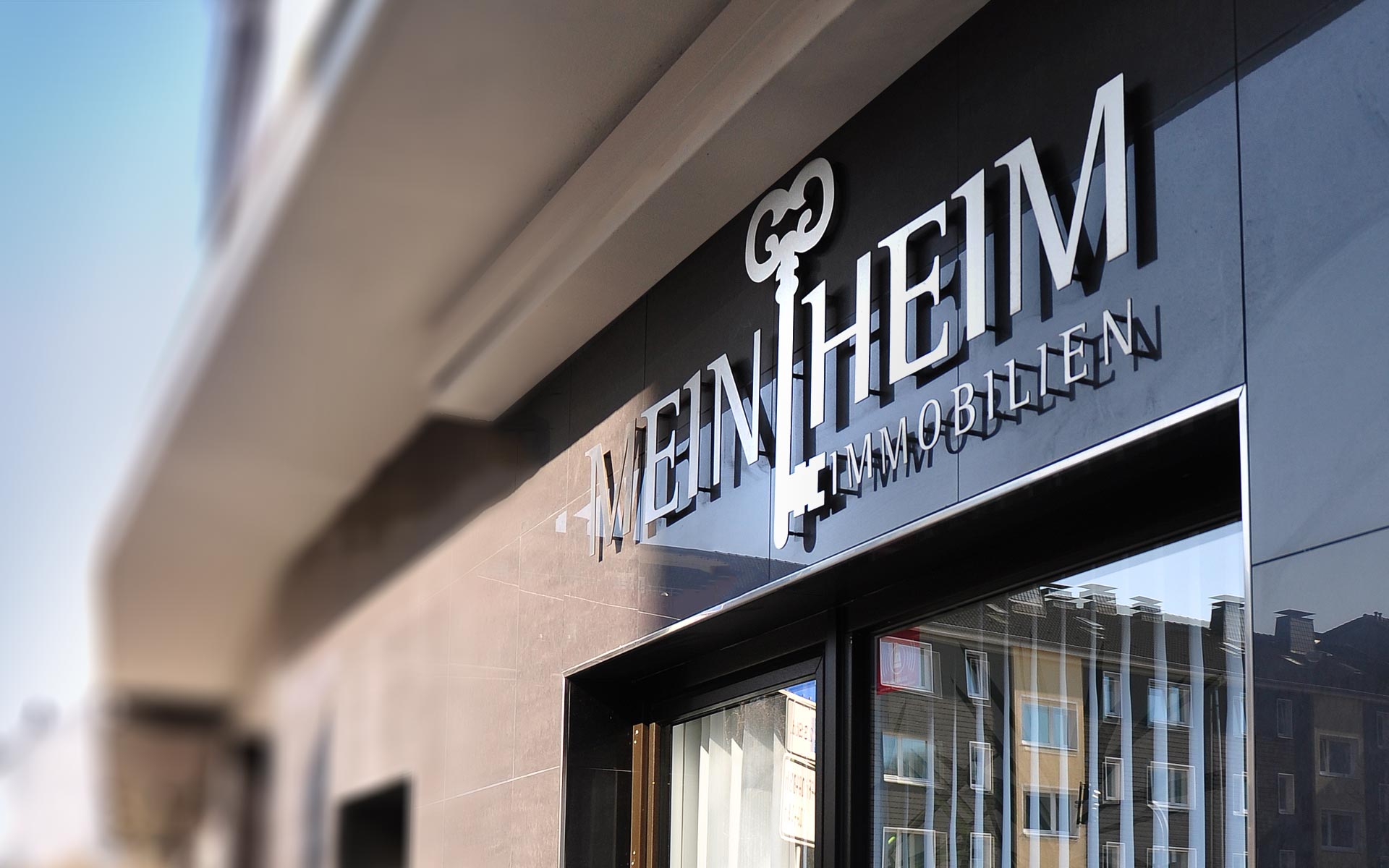 Das Aluminium Logo an der Außenfassade passend zum Corporate Design von MeinHeim Immobilien